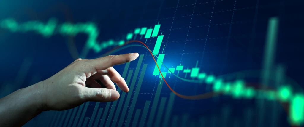 Imagem de análise financeira com gráfico de ações, mostrando uma mão apontando para uma tendência de queda no mercado de investimentos.
