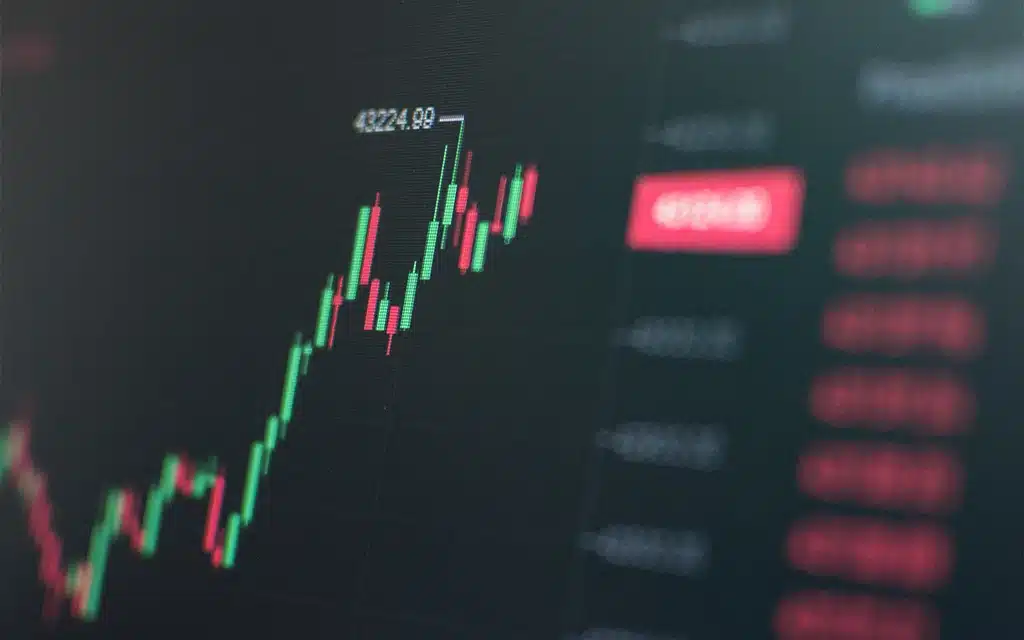 Gráfico financeiro de ações com tendências de alta, com candles verdes e vermelhos, mostrando crescimento no mercado de ações.