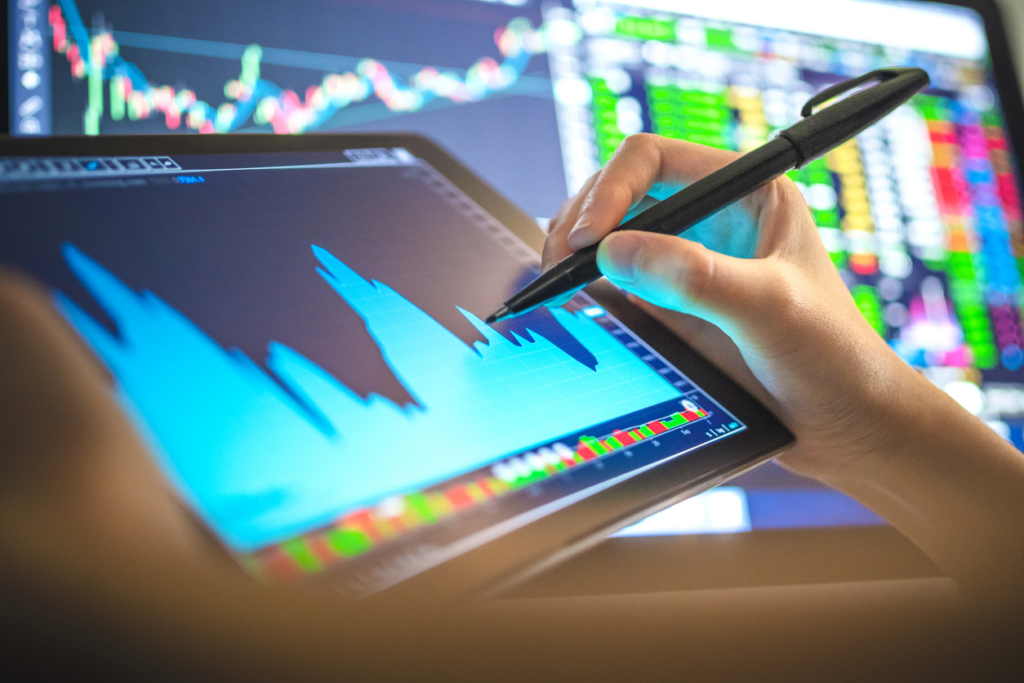 Análise de dados financeiros em dispositivo digital, com gráficos de ações e indicadores de mercado, representando investimento e bolsa de valores, foco em investimento financeiro.
