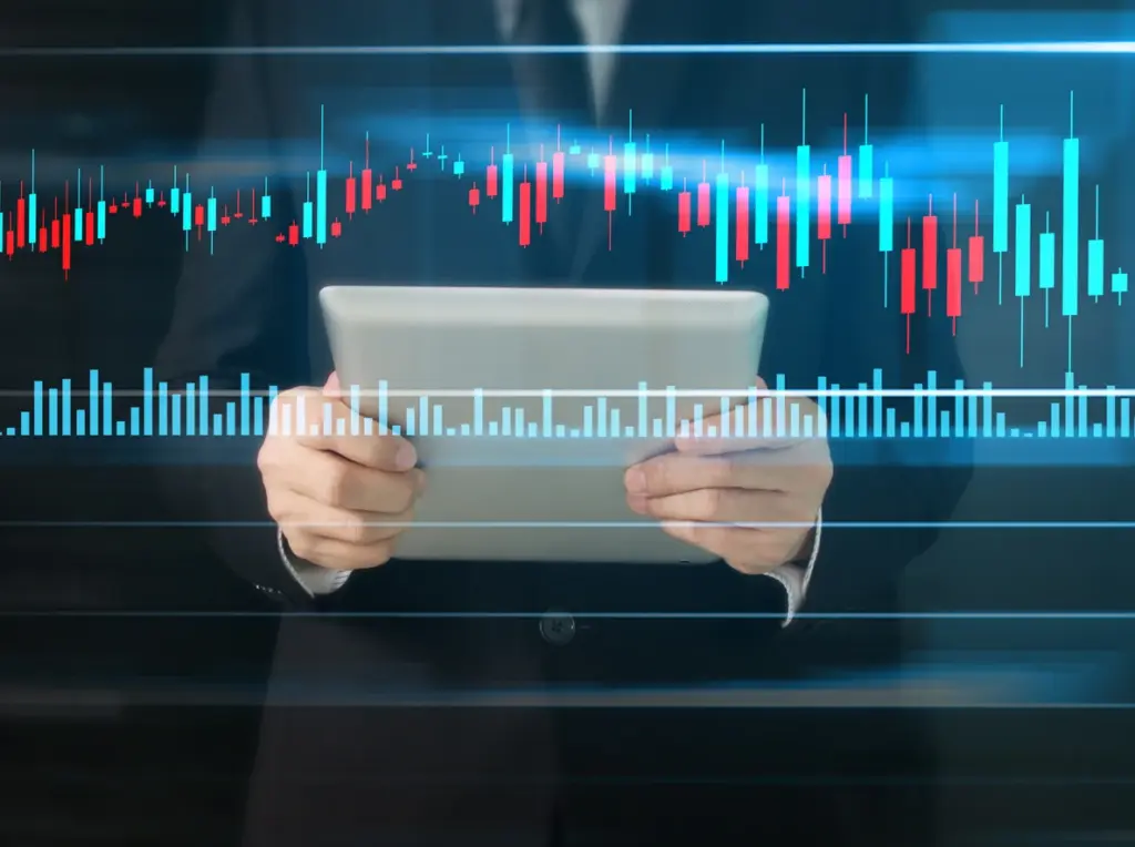 Pessoa segurando tablet com gráficos e indicadores financeiros digitais, representando análise de mercado financeiro e investimentos.