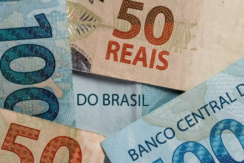 Imagem com várias notas de dinheiro do Brasil, incluindo notas de 50 e 100 reais, simbolizando valores e economia brasileira.