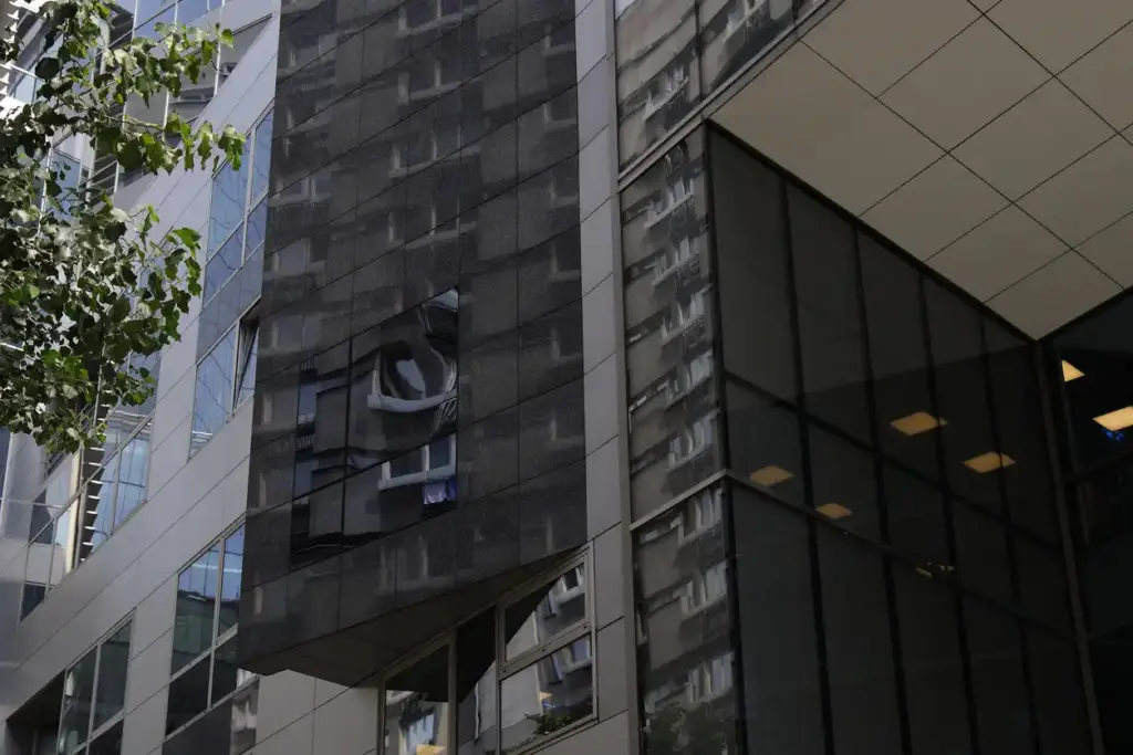 Imagem de edifícios modernos em uma área urbana, com fachadas de vidro e demonstração de arquitetura contemporânea na cidade.