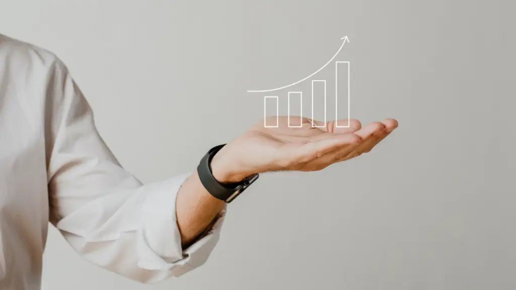 Pessoa segurando a mão com uma ilustração de gráfico de crescimento de negócios e progresso financeiro acima dela, simbolizando sucesso empresarial e análise de crescimento.