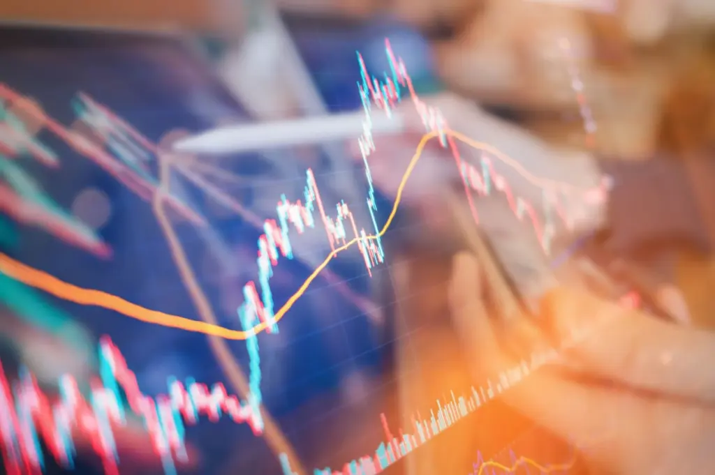 Gráfico de ações em alta com linhas coloridas em movimento, representando análise financeira e investimentos, com fundo desfocado de tecnologia.