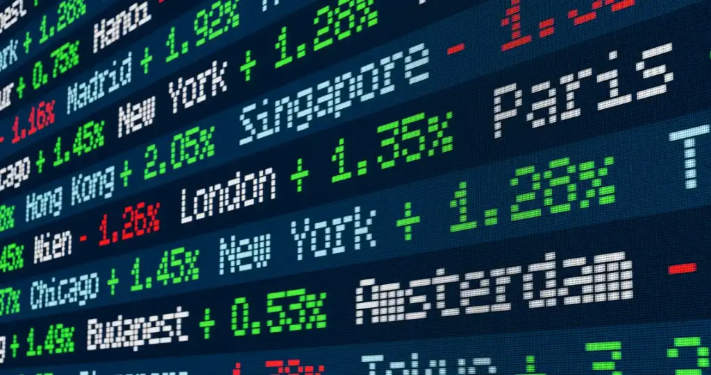 Tela de gráficos e números de negociação no mercado financeiro, com indicadores verdes e vermelhos em destaque, mostrando cotações e variações em tempo real.