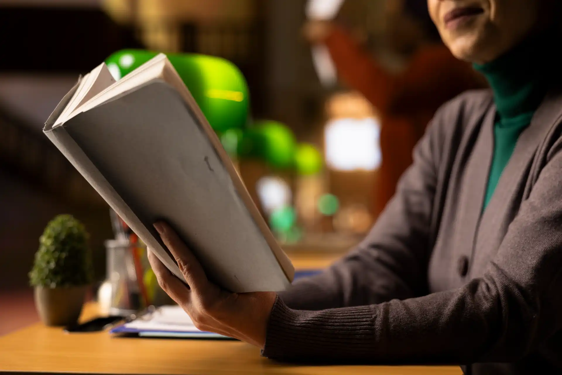Pessoa lendo um livro em um ambiente aconchegante e bem iluminado, com destaque para o ato de leitura. Ideal para quem busca dicas de leitura.